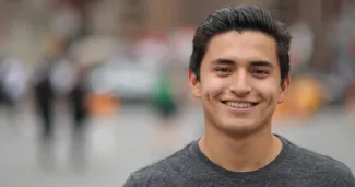 A smiling man outdoors on a city street (illustrative stock photograph)