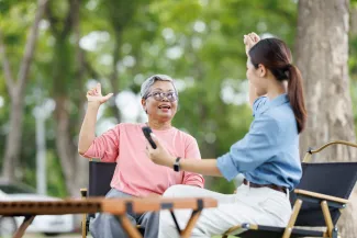 Two women of different ages talking in a park (illustrative stock photograph)