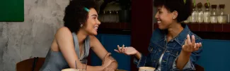 Two women talking over drinks in a café (illustrative stock photograph)